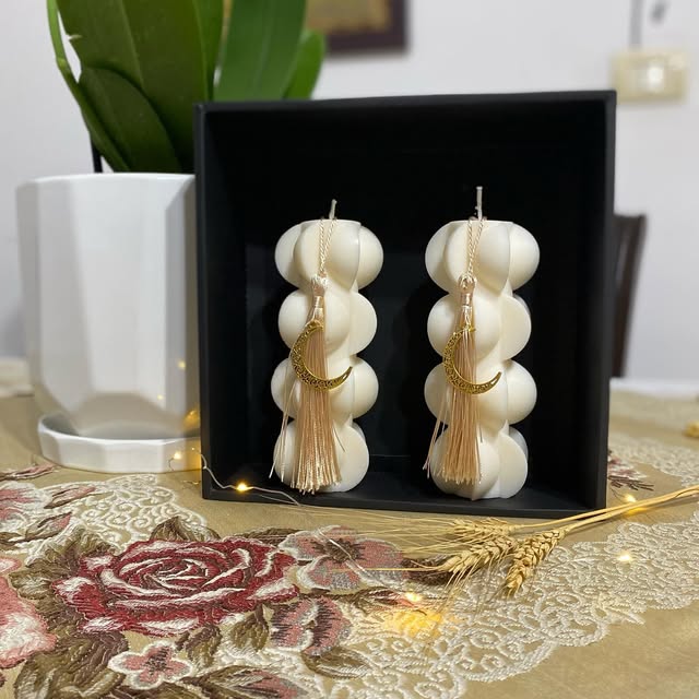 White sculptural bubble candles decorated with gold crescent charms