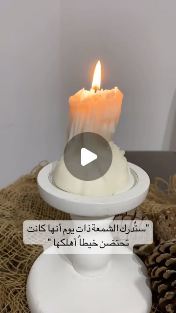Cream sculptural candle glowing on a white plate