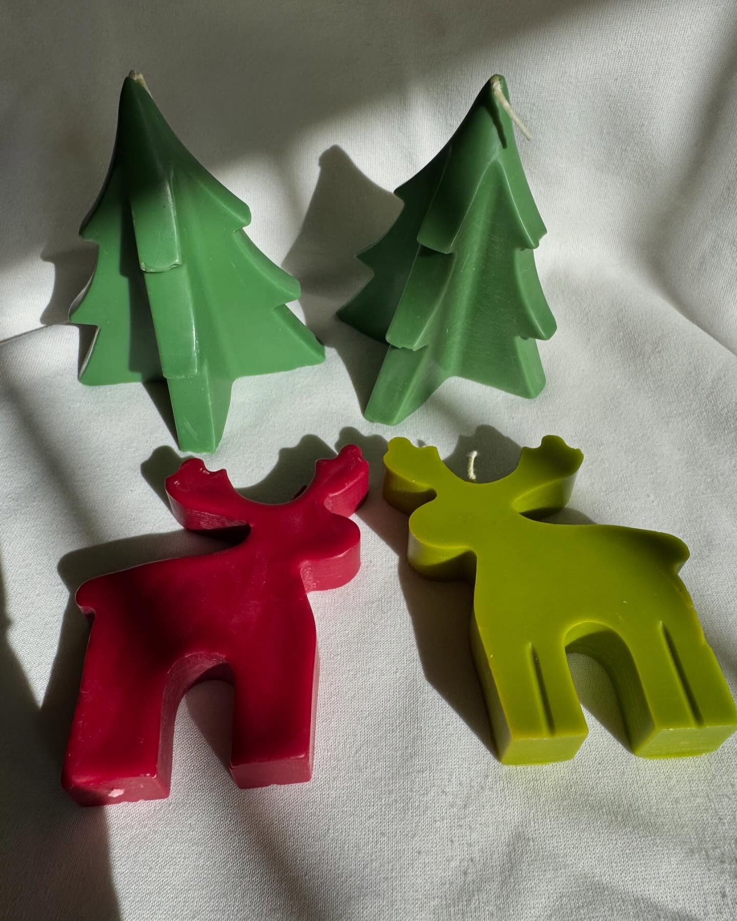 Colorful reindeer and evergreen shaped candles