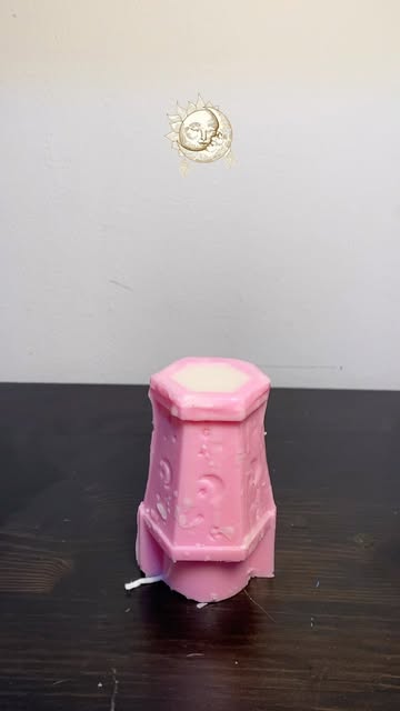 Cream sculpted candle lit on a white plate